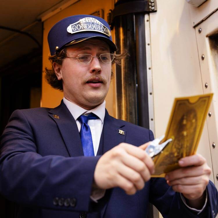 Conductor clipping tickets on board The Polar Express Train Ride