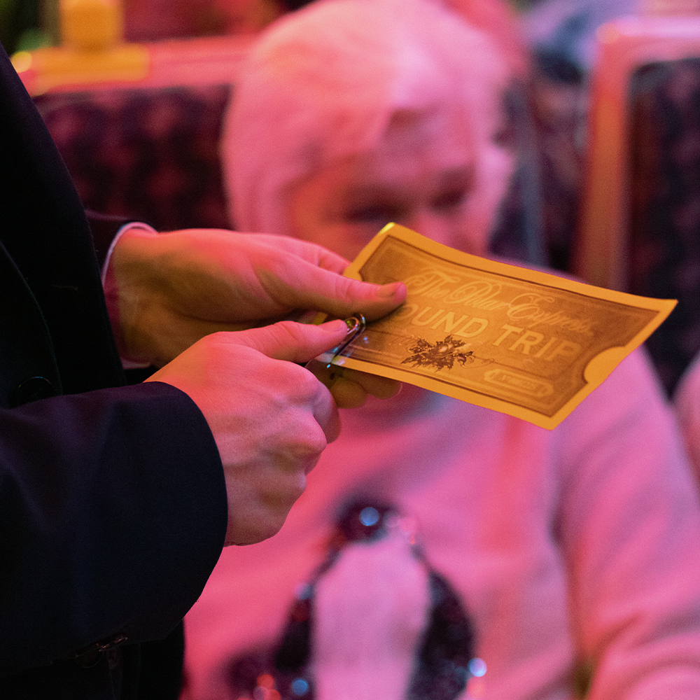 Conductor stamping ticket on board The Polar Express Train Ride Christmas