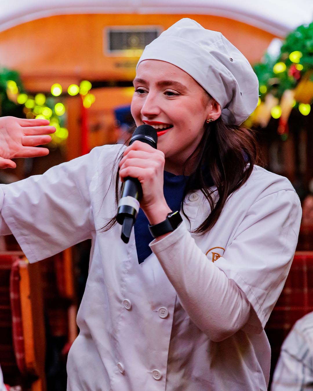 chef waving speaking into microphone on board the polar express train ride