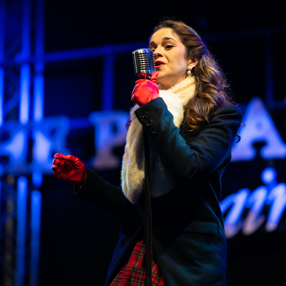 female carol singer singing at the polar express train ride