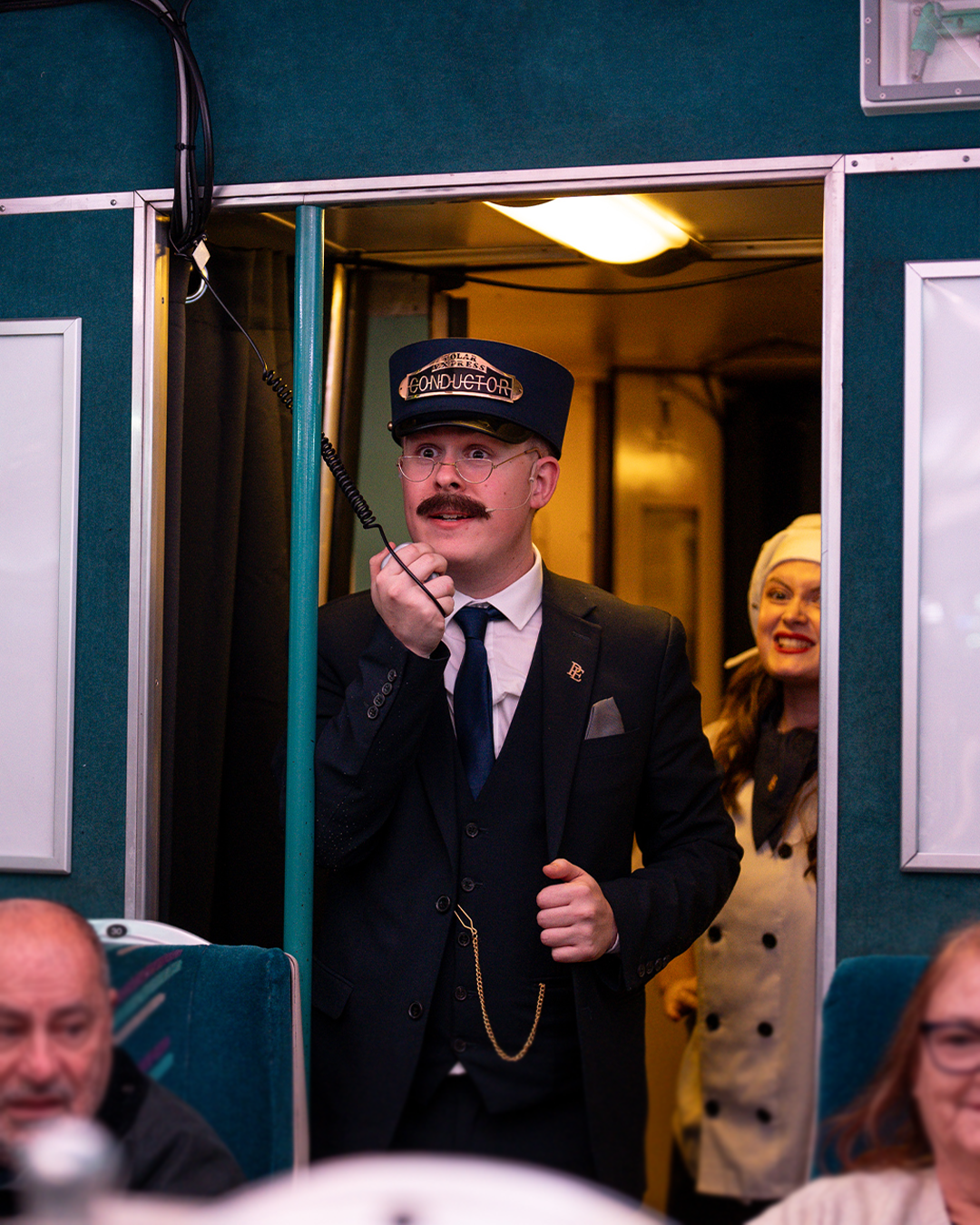 conductor speaking into microphone on board the polar express train ride