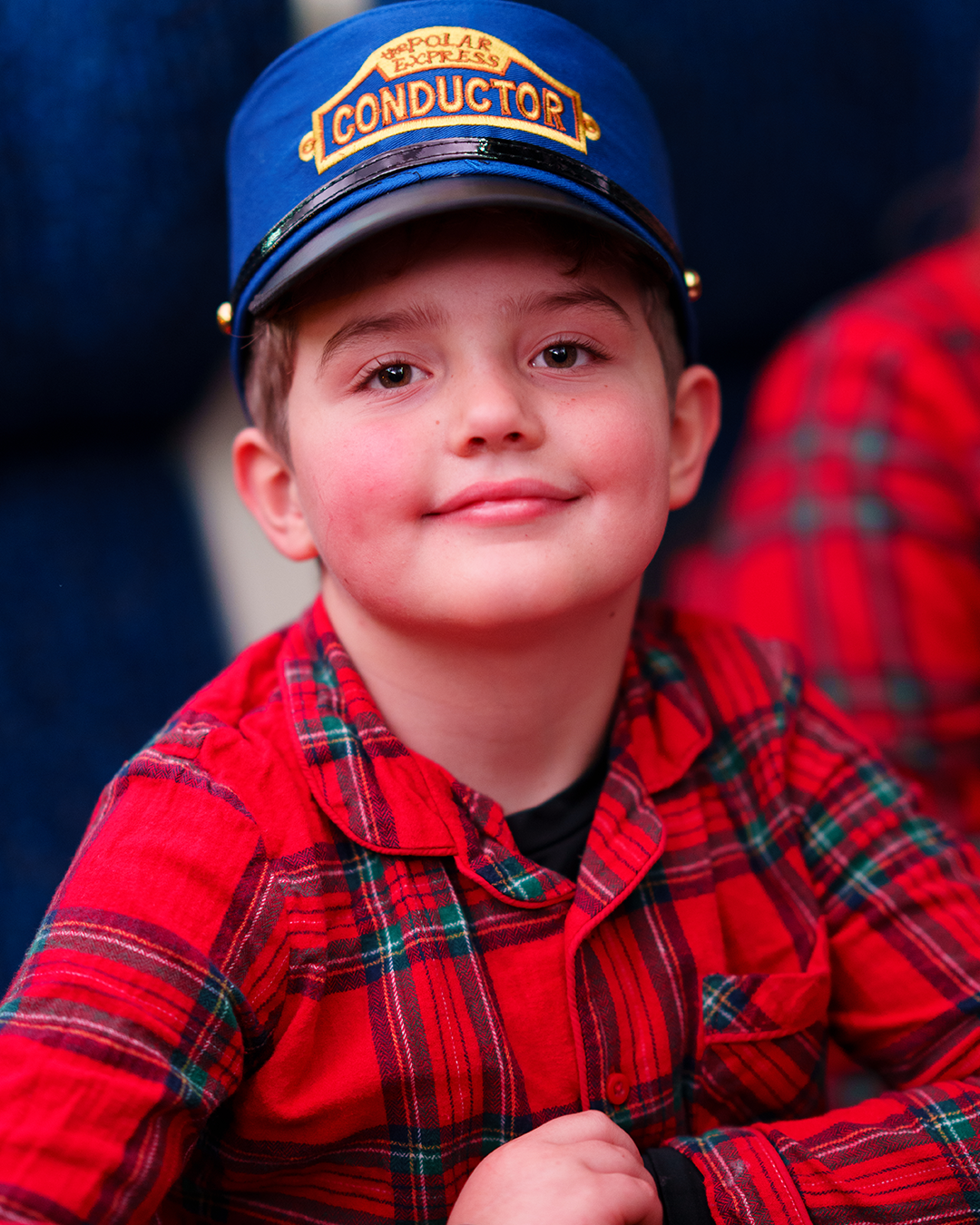 child with conductor hat on board the polar express train ride