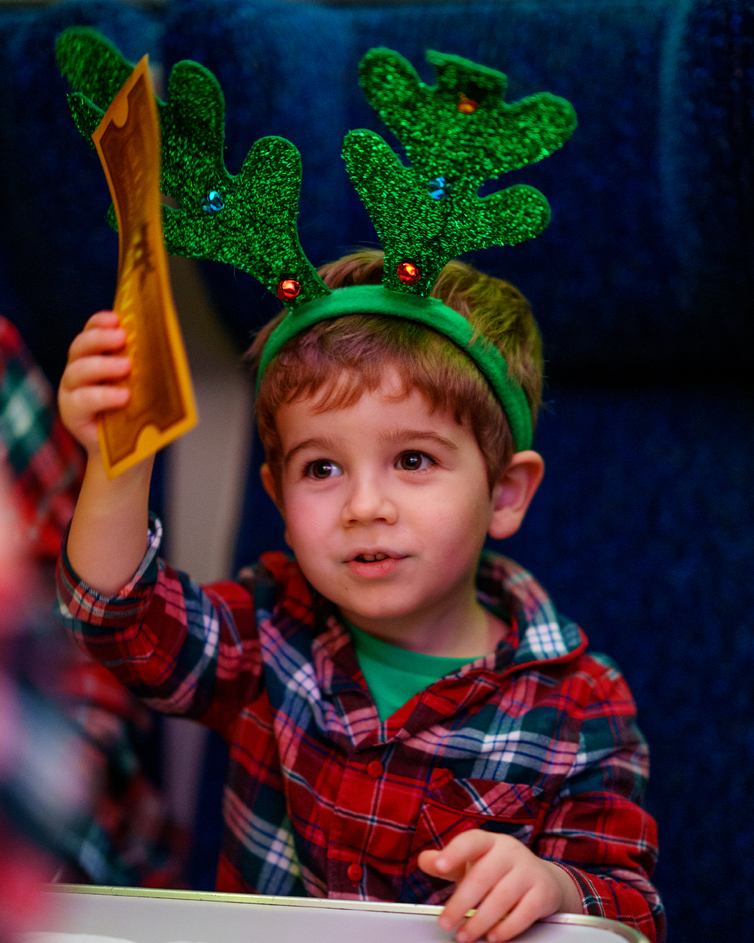 child with golden ticket on board the polar express train ride